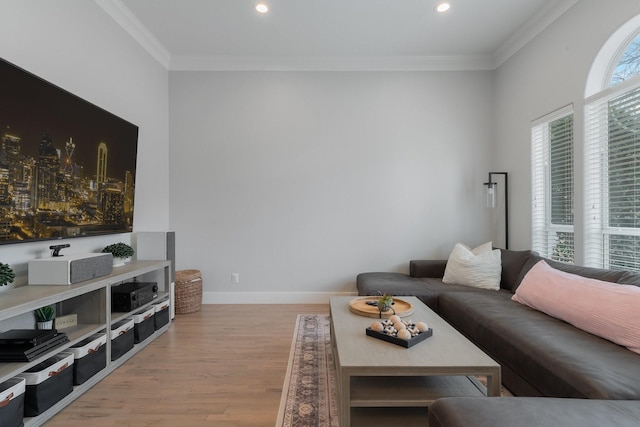 living area with a wealth of natural light, baseboards, crown molding, and light wood finished floors