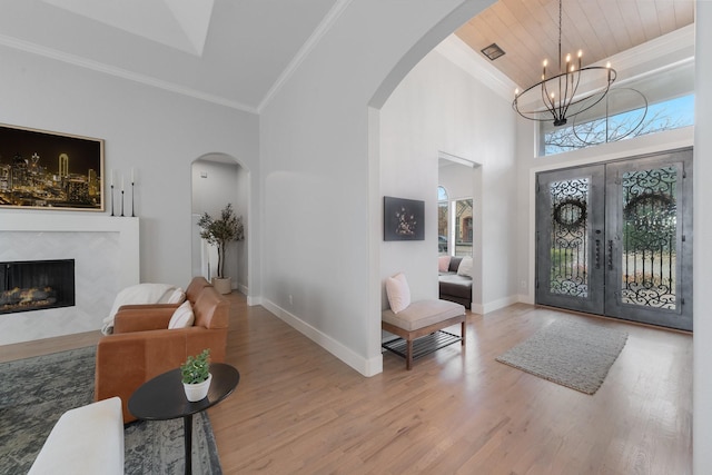 entrance foyer with baseboards, crown molding, and light wood finished floors