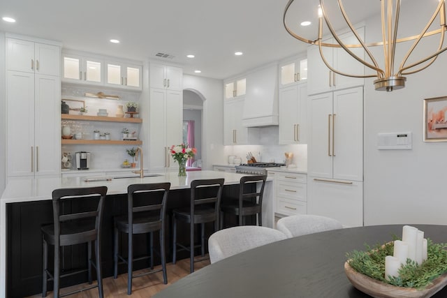 kitchen with light countertops, premium range hood, and white cabinetry