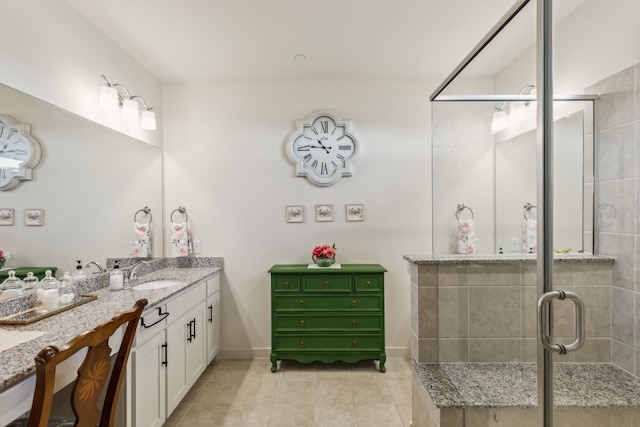 bathroom with a shower stall, baseboards, tile patterned flooring, and vanity