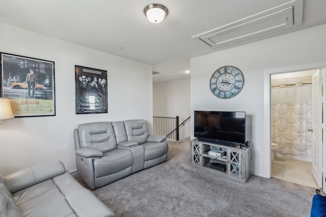 tiled living room with attic access and carpet floors