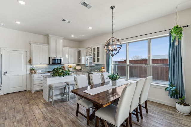 dining area featuring light wood-type flooring, visible vents, a notable chandelier, and recessed lighting