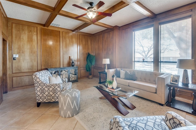 living room with visible vents, coffered ceiling, beamed ceiling, wood walls, and light tile patterned flooring