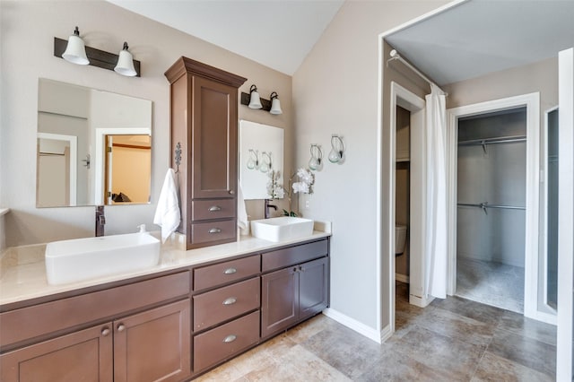 bathroom with a sink, a spacious closet, and double vanity