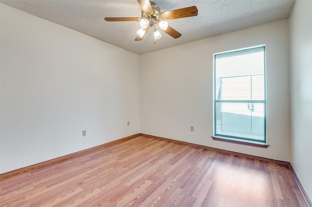 empty room with light wood-style floors, baseboards, a ceiling fan, and a textured ceiling