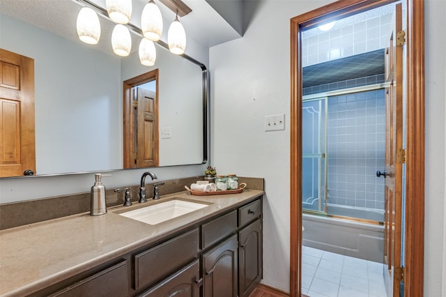 bathroom with bath / shower combo with glass door, tile patterned flooring, and vanity