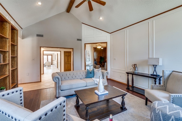 living area with light wood-style floors, visible vents, a decorative wall, and beamed ceiling