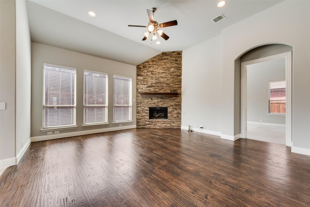 unfurnished living room with lofted ceiling, dark wood-style flooring, visible vents, and a fireplace