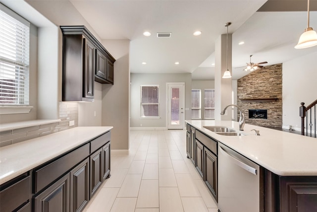 kitchen with dishwasher, light countertops, open floor plan, and a sink