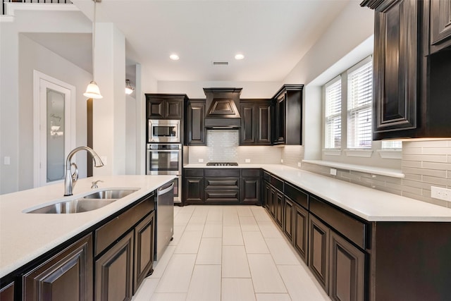 kitchen with premium range hood, pendant lighting, a sink, and light countertops