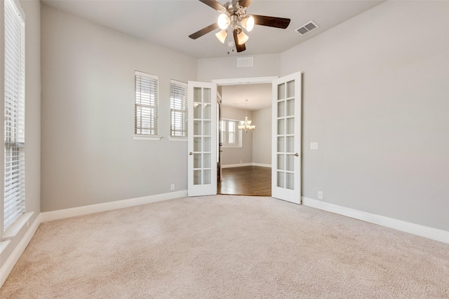 empty room featuring french doors, carpet flooring, visible vents, and baseboards