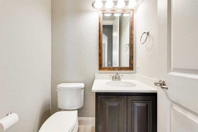 half bath featuring toilet and vanity