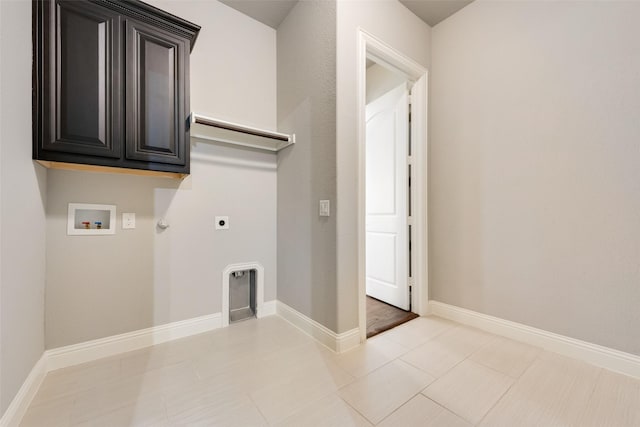 clothes washing area featuring cabinet space, baseboards, hookup for a gas dryer, hookup for a washing machine, and hookup for an electric dryer