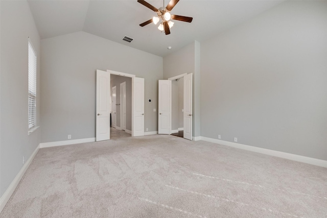 unfurnished bedroom featuring light carpet, baseboards, visible vents, a ceiling fan, and lofted ceiling