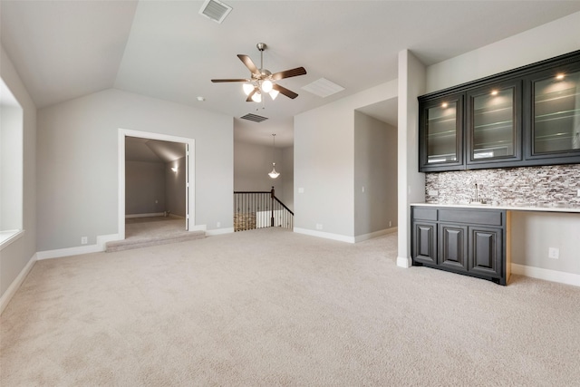 unfurnished living room featuring a ceiling fan, light colored carpet, visible vents, and vaulted ceiling