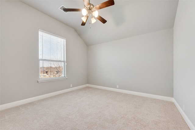 empty room featuring lofted ceiling, carpet floors, ceiling fan, and baseboards