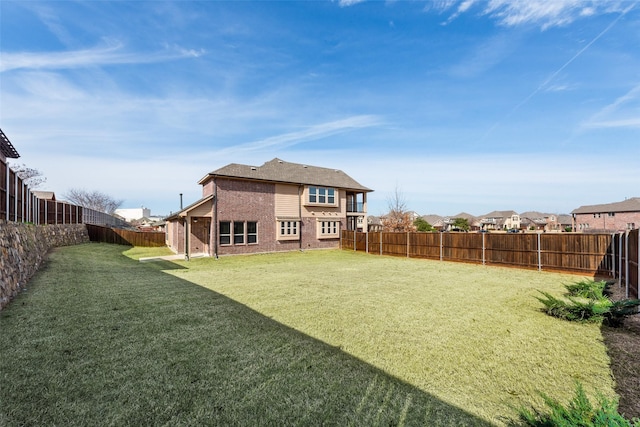 back of house with a yard, a residential view, a fenced backyard, and brick siding