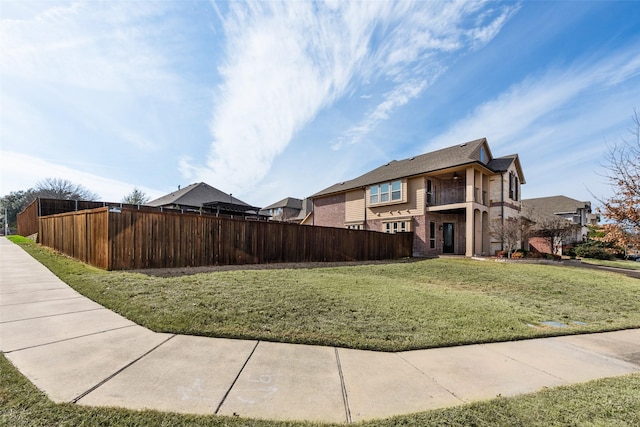 view of property exterior with a yard, brick siding, and fence