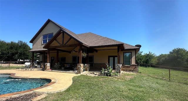 rear view of house with a patio, a yard, and fence