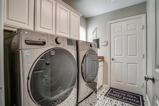 laundry area featuring cabinet space, washing machine and dryer, light tile patterned floors, and baseboards