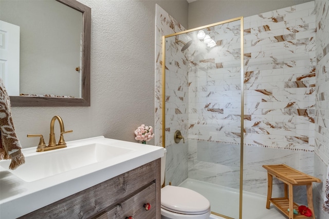 bathroom featuring a textured wall, vanity, toilet, and walk in shower