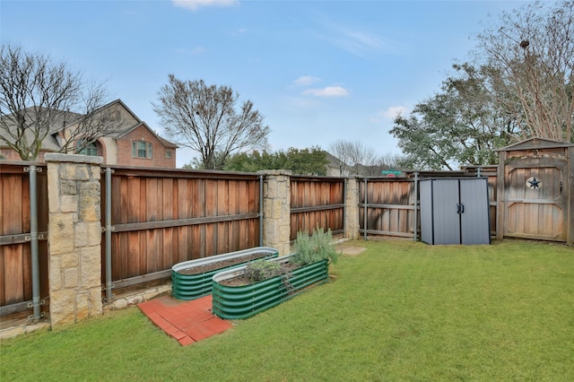 view of yard with a vegetable garden, fence, and a storage unit