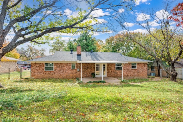 back of house featuring a patio area, a chimney, fence, and a lawn