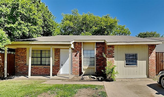 view of front of property featuring a front yard, brick siding, and fence