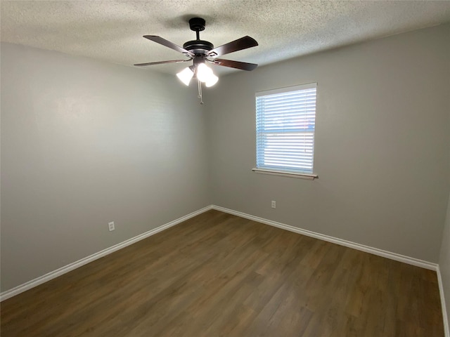 unfurnished room featuring a ceiling fan, dark wood finished floors, and baseboards