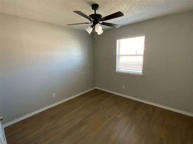 unfurnished room featuring a textured ceiling, ceiling fan, dark wood finished floors, and baseboards