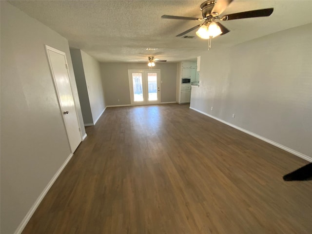 empty room with ceiling fan, baseboards, dark wood finished floors, and a textured ceiling