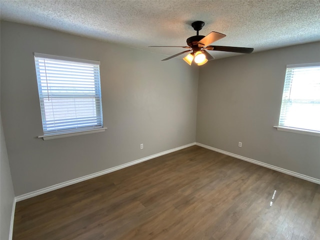 empty room with ceiling fan, baseboards, and dark wood-type flooring