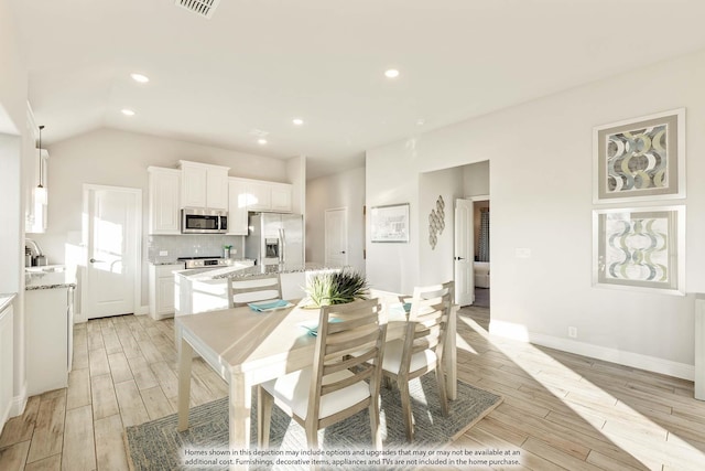 dining area featuring wood finish floors, recessed lighting, visible vents, vaulted ceiling, and baseboards