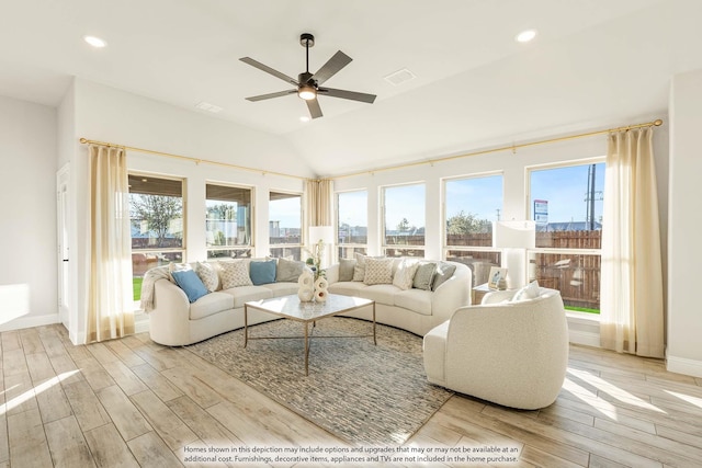 living area with light wood-type flooring, a city view, and a wealth of natural light