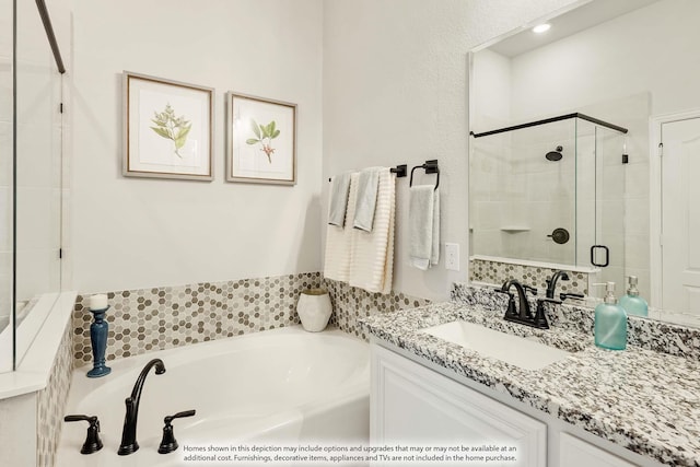 full bath with a garden tub, a shower stall, and vanity