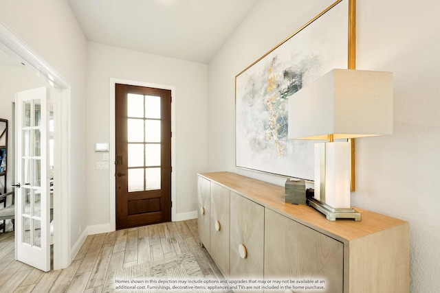 entryway with light wood finished floors and baseboards