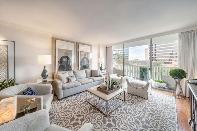living room with crown molding, wood finished floors, and floor to ceiling windows