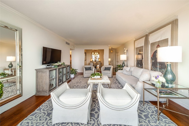 living room with a chandelier, wood finished floors, baseboards, and ornamental molding
