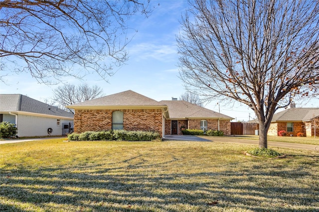 ranch-style home featuring brick siding, a chimney, a shingled roof, a front yard, and fence