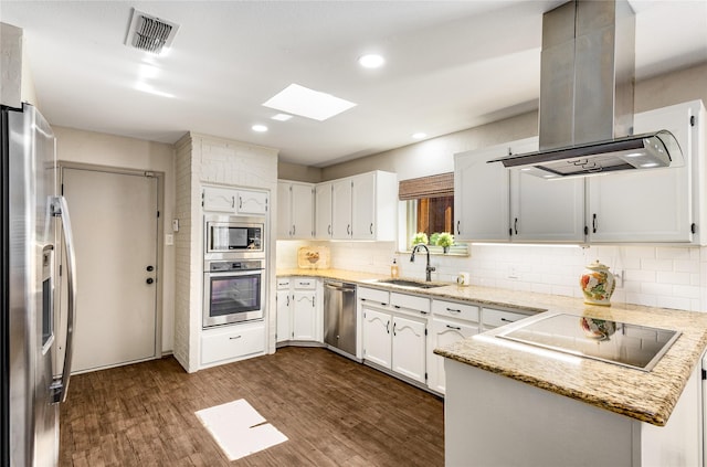 kitchen featuring dark wood finished floors, island exhaust hood, stainless steel appliances, visible vents, and a sink