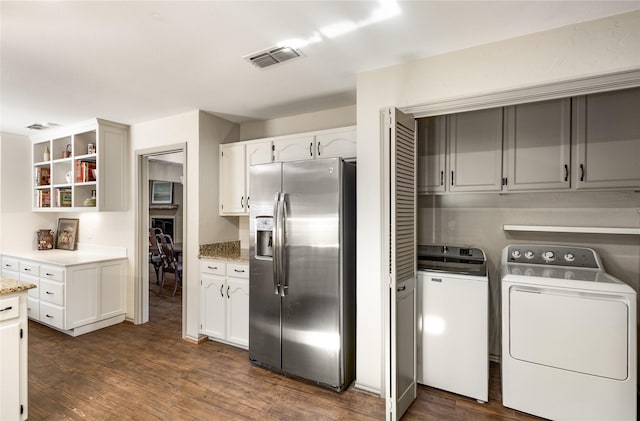 kitchen featuring visible vents, stainless steel fridge with ice dispenser, dark wood-type flooring, washing machine and dryer, and open shelves