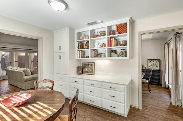 dining room featuring dark wood-type flooring, french doors, and visible vents