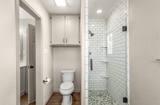 full bath with wood finished floors, a shower stall, toilet, and baseboards