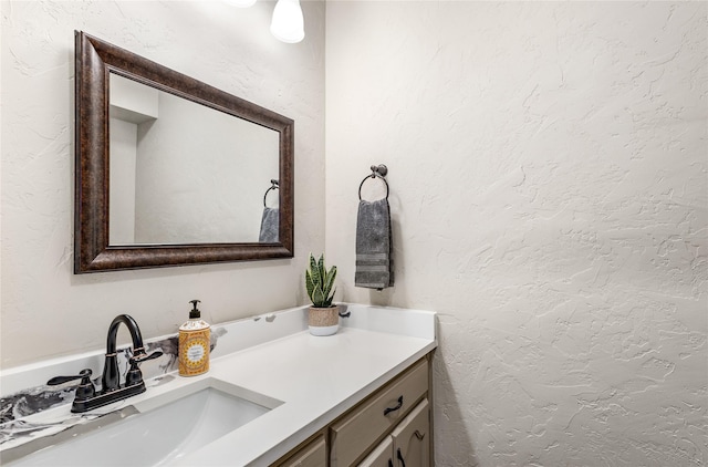 bathroom featuring a textured wall and vanity