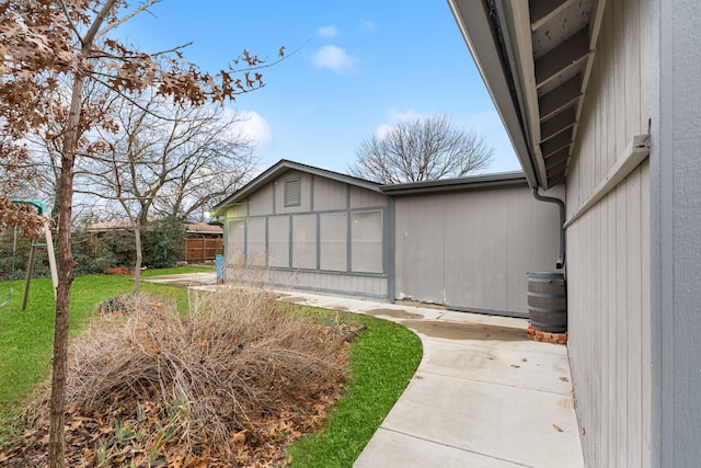 view of side of property with fence and a yard