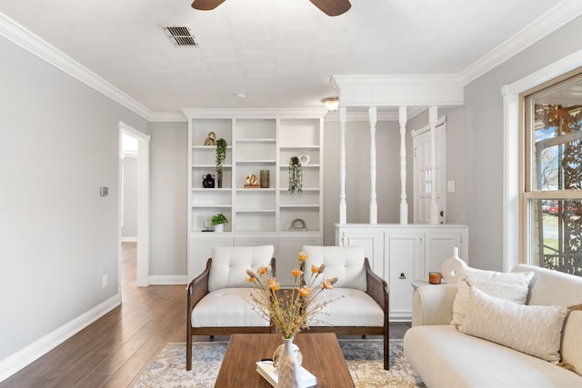 living area featuring crown molding, visible vents, ceiling fan, baseboards, and hardwood / wood-style flooring