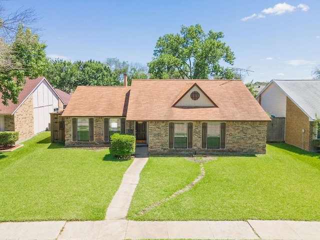 ranch-style house featuring a front lawn, fence, and brick siding