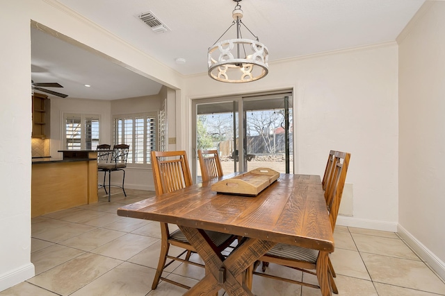 dining area with crown molding, a notable chandelier, light tile patterned floors, visible vents, and baseboards