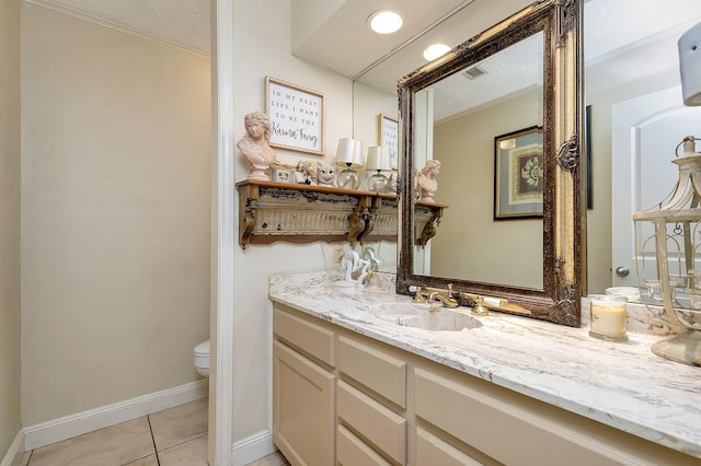 bathroom featuring toilet, visible vents, baseboards, vanity, and tile patterned floors