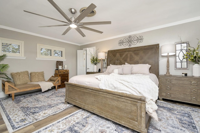 bedroom with ornamental molding, ceiling fan, and wood finished floors